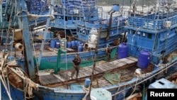 Police officers stand on a fishing boat during a police inspection at the pier of Songkhla, south Thailand, Dec. 23, 2015. Thailand said seafood exports to the United States, Europe and Australia have not been hit by reports of slavery and forced labor by campaign groups and media. Australia is proposing laws to make it a leader in fighting slavery.