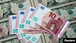 FILE - A photo illustration shows U.S. Dollar and euro banknotes in Vienna, March 16, 2015. 