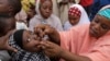 FILE- Seorang pejabat kesehatan tak dikenal memberikan vaksin polio kepada seorang anak di Kawo Kano, Nigeria, 13 April 2014. (AP/ Sunday Alamba, File)