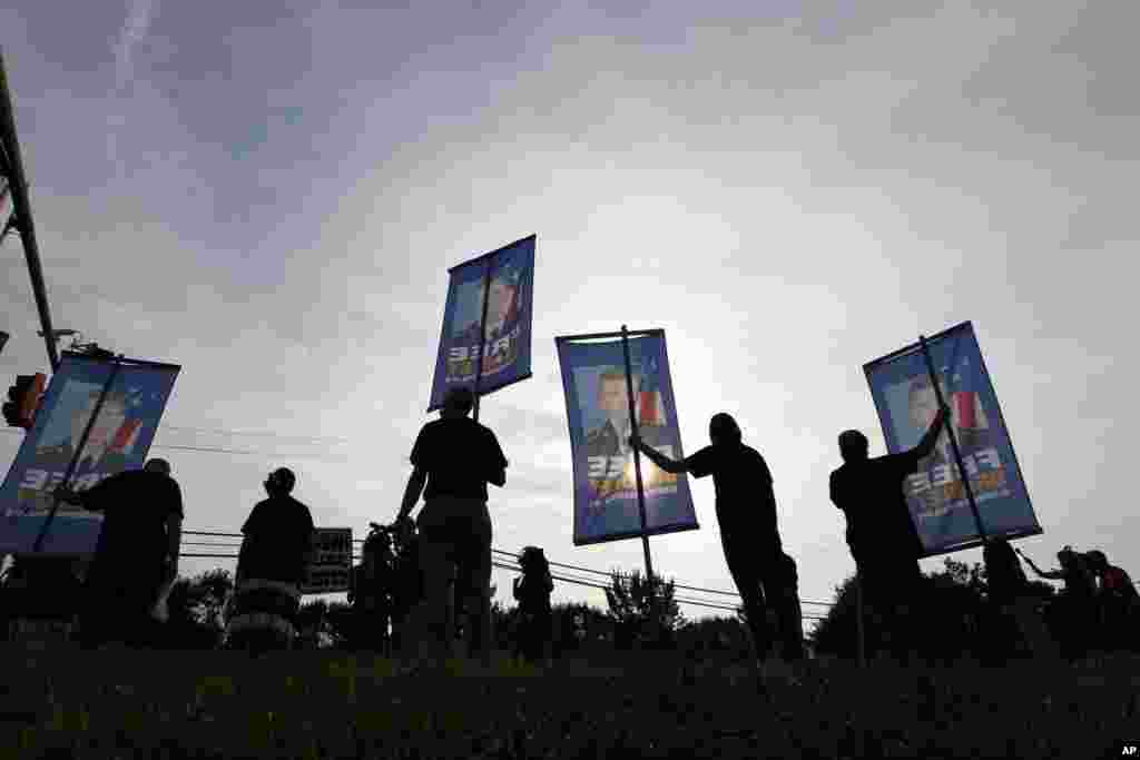 Para pendukung Prajurit Kelas Satu Bradley Manning mengacungkan poster-poster dalam sebuah protes di luar gerbang Fort Meade, Maryland (21/8). (AP/Jose Luis Magana)