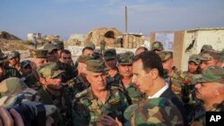Presiden Suriah Bashar Assad, kanan tengah, berbicara dengan pasukan Suriah selama kunjungannya ke kota strategis Habeet, Idlib, Suriah. (Foto: AP)