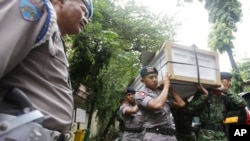 Indonesian police officers and soldiers carry one of the coffins prepared for the victims of a military helicopter which crashed in Poso, Central Sulawesi, at hospital in Jakarta, Indonesia, March 21, 2016. 