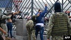Soldiers frisk two men suspected of belonging to a criminal gang remain detained during a joint operation between the Ecuadorean National Police and members of the armed forces to prevent violent acts, in Guayaquil, Ecuador, on Jan.15, 2024.