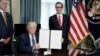 U.S. President Donald Trump displays a financial services executive order as Treasury Secretary Steven Mnuchin looks on during a signing ceremony at the Treasury Department in Washington, April 21, 2017.