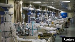 Petugas medis mengenakan pakaian pelindung khusus tengah menangani pasien di bangsal ICU sebuah rumah sakit di Wuhan, Hubei, China, 6 Februari 2020.