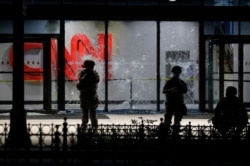 FILE - Members of the Georgia National Guard stand in front of shattered glass at the CNN Center in the aftermath of a demonstration against police violence on May 30, 2020, in Atlanta.
