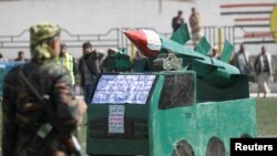 FILE - A Houthi militant stands in front of a cardboard model of a missile during a gathering to mark 1,000 days of the Saudi-led military intervention in the Yemeni conflict, in Sana'a, Yemen, Dec. 21, 2017.