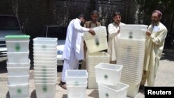 Para petugas pemilu tengah mempersiapkan kotak suara yang akan dipergunakan untuk penyelenggaraan pemilu di salah satu kantor Pemilihan Umum Nasional di Quetta, Pakistan (8/5),