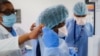 Tenaga medis mengenakan APD mereka saat bekerja di departemen darurat di NYC Health + Hospitals Metropolitan di New York, 27 Mei 2020. (AP Photo/John Minchillo, File).