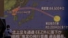 Orang-orang berjalan di depan layar yang menampilkan laporan berita tentang Korea Utara yang menembakkan rudal balistik di atas Jepang, di Tokyo, Jepang, 4 Oktober 2022. (Foto: REUTERS/Issei Kato)
