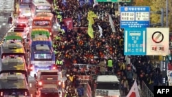 2024年12月4日，參加反對南韓總統尹錫悅遊行的抗議者前往首爾總統府。 (法新社）