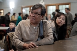 S'Tha Sein, left, and his daughter Lunn KyiPhyu Tha, 15, right, both immigrants from Myanmar, also known as Burma, speak with a reporter from The Associated Press following services, Feb. 16, 2020, at the Overseas Burmese Christian Fellowship.