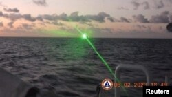 A green light appears from the direction of a Chinese coast guard ship at the Second Thomas Shoal, 105 nautical miles off the Palawan Province, Philippines, February 6, 2023 in this handout image. Philippine Coast Guard/Handout via REUTERS