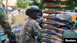 FILE - A South Sudan army soldier stands next to a machine gun mounted on a truck in Malakal town, some 500 km (312 miles) northeast of the capital, Juba, Dec. 30, 2013. South Sudan has been found to be among the countries cutting back on military spending due to low oil prices.