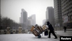 FILE - A man carries scraps in a handcart during snowfall in central Seoul, South Korea, Feb. 16, 2016. With the recycling market dimming, Seoul is turning to upcycling to reduce waste.