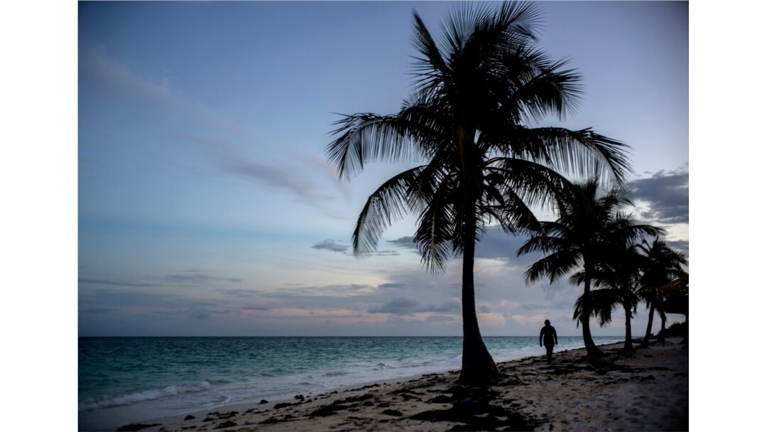 A woman walks along a beach before the arrival of Hurricane Dorian in Freeport, Grand Bahama, Bahamas, Aug. 31, 2019.