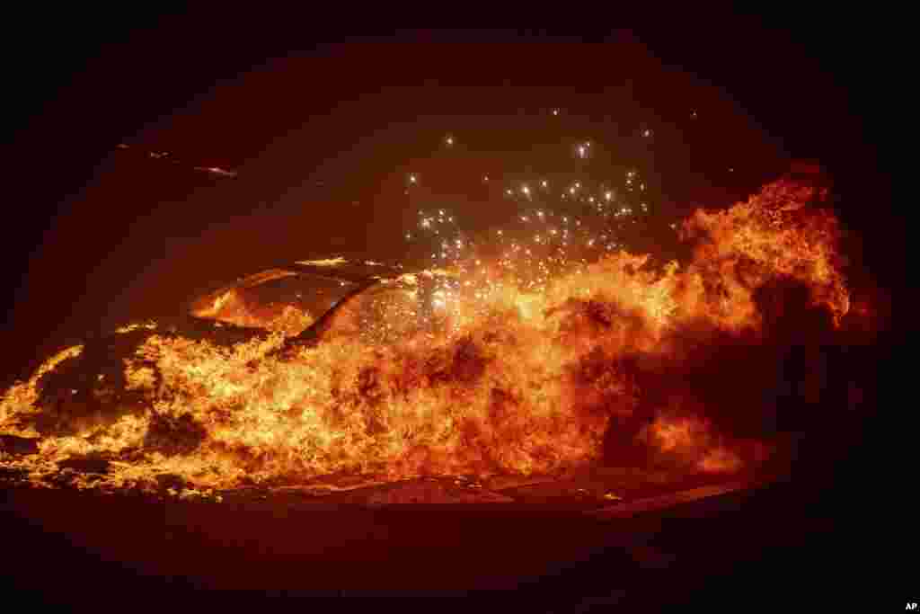 Um veículo incendeia-se enquanto o incêndio em Palisades avança no bairro de Pacific Palisades, em Los Angeles, a 7 de janeiro de 2025.