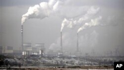 FILE - Smoke billows from chimneys of the cooling towers of a coal-fired power plant in Dadong, Shanxi province, China.