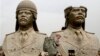 FILE - U.S. soldiers walk past two gigantic status of former Iraqi President Saddam Hussein in Baghdad, March 20, 2009.
