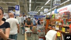 Orang-orang menanti gilirannya untuk membayar meja kasir yang bekerja denagn lambat di sebuat supermarket di Kiev, Ukraina, hari Rabu, 28 Juni 2017 (foto: AP Photo/Efrem Lukatsky)