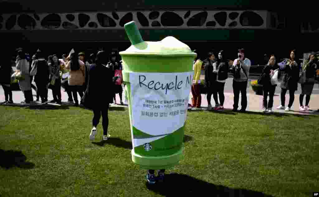 4月22日在韩国首尔的市政厅前,一名志愿者把自己装扮成一次性纸杯,参加环保人士发起的庆祝地球日活动。