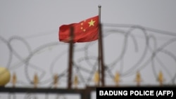 资料照片：新疆喀什以南一处住宅区的铁丝网和中国国旗。(2019年6月4日)