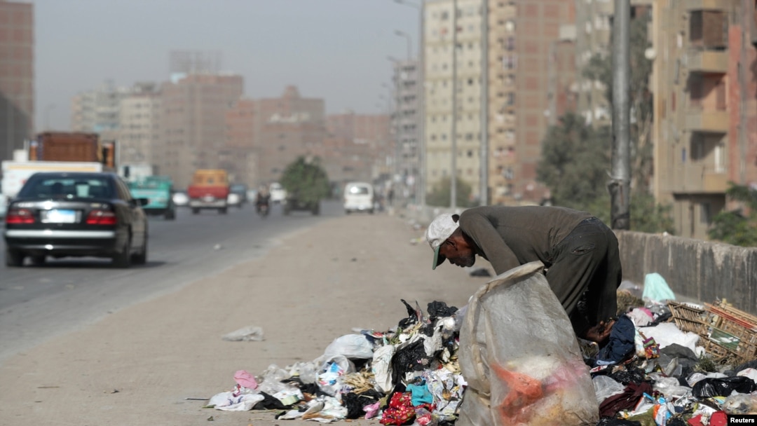 FILE - A man picks through rubbish on a road in Cairo, Egypt, Oct. 29, 2018.