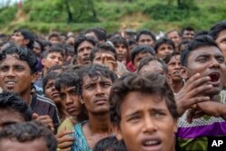 Rohingya Muslims, who crossed over from Myanmar into Bangladesh, wait their turn to collect aid near Balukhali refugee camp, Bangladesh, Sept. 20, 2017.