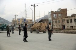 Afghan security personnel and British soldiers with NATO-led Resolute Support Mission forces arrive at the site of an attack in Kabul, March 25, 2020.