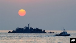 FILE - A South Korean ship (R) sails by Navy MSB (Movement Sea Base) off the South Korea-controlled island of Yeonpyeong near the disputed waters of the Yellow Sea.