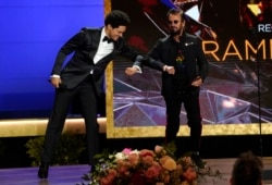 Trevor Noah, kiri, dan pembawa acara Ringo Starr tampil di atas panggung di Grammy Awards tahunan ke-63 di Los Angeles Convention Center pada hari Minggu, 14 Maret 2021. (Foto: AP/Chris Pizzello)