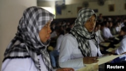 Seorang TKI yang akan berangkat ke Timur Tengah memegang paspor dan dokumen-dokumennya di kantor keimigrasian Tangerang, Banten.
