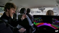 Dalam foto yang diambil hari Senin, 10 April 2017 ini, CEO Luminar, Austin Russell memberi isyarat tangan ketika memperhatikan peta 3D yang dihasilkan sistem pendeteksi cahaya dan jarak dalam sebuah demonstrasi pengendaraan di San Fransisco (foto: AP Photo/Ben Margot)