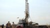 Workers are seen at an oil exploration site in Bulisa district approximately 244km (152 miles) North-West of Kampala, January 20, 2012. 