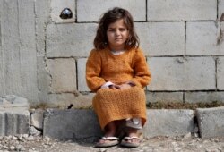 A displaced Syrian girl sits outside her family's tent at a refugee camp in Bar Elias, Bekaa Valley, Lebanon, Friday, March 5, 2021. UNICEF said, March 10, 2021 that Syria’s 10-year-long civil war has killed or wounded about 12,000 children.