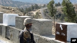 FILE - A Pakistani soldier stands guard at a border fence between Pakistan and Afghanistan, at Angore Adda, Pakistan, Oct. 18, 2017. Pakistan said Thursday that suspected militants operating out of Afghanistan have attacked several border outposts.