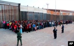 FILE - The U.S. Customs and Border Protection detains migrants who crossed the U.S.-Mexico border in El Paso, Texas, May 29, 2019.