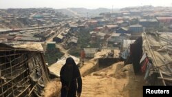 Seorang perempuan berjalan ke arah bukit di kamp pengungsi Rohingya di Kutupalong, di bagian selatan Bangladesh, 11 Februari 2018.