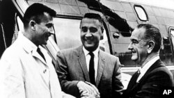 فضانوردان جان یانگ و گاس گریسوم در حال دست دادن با پرزیدنت لیندون جانسون، ۲۸ ژانویه ۱۹۶۷