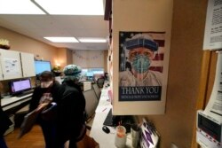 In this Aug. 18, 2021, file photo, a poster honoring medical and frontline workers, hangs on a nursing station of an intensive care unit, at the Willis-Knighton Medical Center in Shreveport, La.