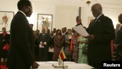 Zimbabwe President Robert Mugabe swearing in then-Vice President John Nkomo, Harare, Dec. 14, 2009. (File Photo)