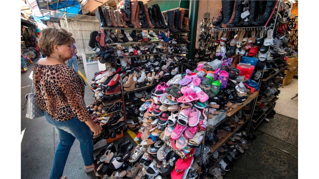 FILE - A woman shops for Chinese made shoes, Aug. 24, 2019, at a store in the Chinatown area of Los Angeles.