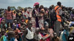 FILE - Men, women and children line up to be registered with the World Food Program for food distribution in Old Fangak, in Jonglei state, one of the worst affected areas for food insecurity in South Sudan, June 17, 2017.
