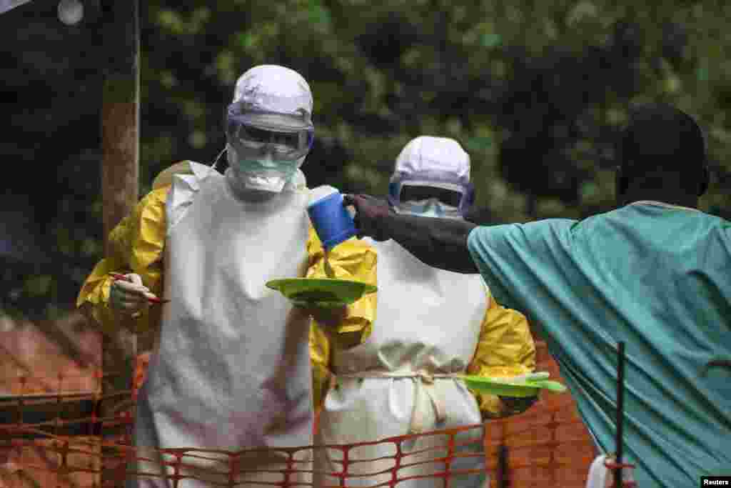 Medical staff working with Medecins Sans Frontieres (MSF) prepare to bring food to patients kept in an isolation area at the MSF Ebola treatment center, in Kailahun, July 20, 2014. 