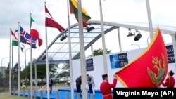 Para prajurit Montenegro membentangkan bendera nasional dalam sebuah upacara untuk menandai bergabungnya Montenegro di Markas Besar NATO di Brussels hari Rabu, 7 Juni 2017 (foto: AP Photo/Virginia Mayo)