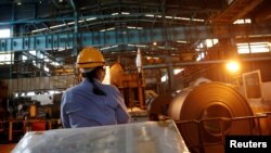 台灣高雄一家軋鋼廠的工人在使用遙控工具工作。（資料圖片）