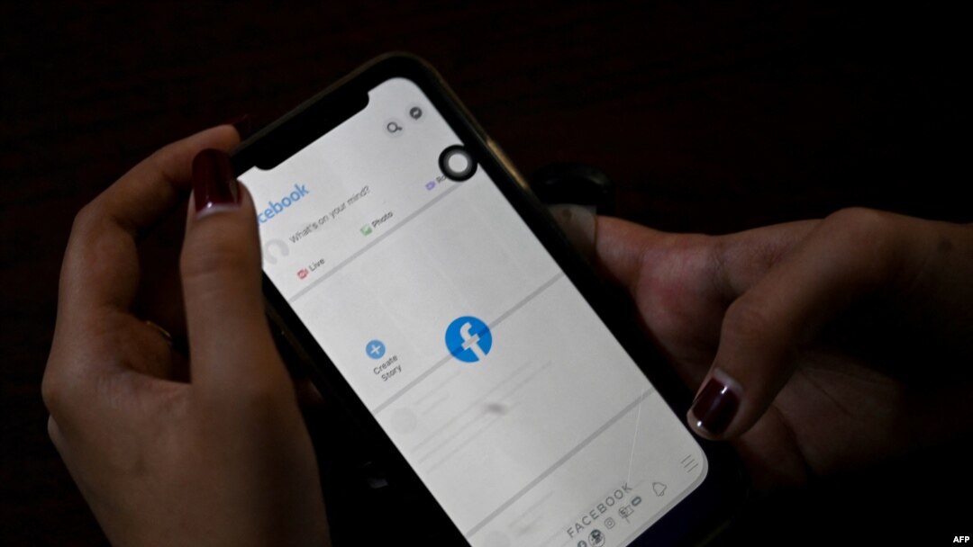 一名婦女使用手機在仰光查看Facebook，緬甸將軍在奪權數天后下令互聯網提供商限制訪問Facebook。（2021年2月4日） （STR /法新社） 