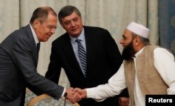 Russian Foreign Minister Sergei Lavrov welcomes member of Taliban delegation Alhaj Mohammad Sohail Shaina during the multilateral peace talks on Afghanistan in Moscow, Russia, Nov. 9, 2018.