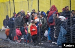 FILE - Migrants wait to cross the border from Slovenia into Spielfeld in Austria, Feb. 16, 2016.