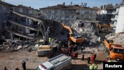 Emergency personnel work at the site of damaged buildings after an earthquake in Elazig, Turkey, Jan. 27, 2020. 